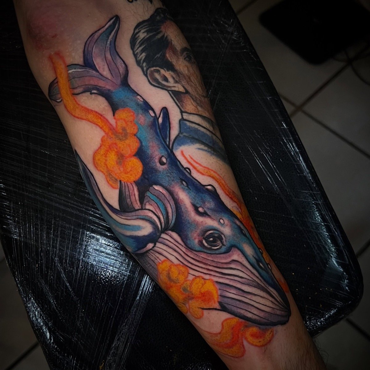 Tatuaje de ballena con flores naranjas